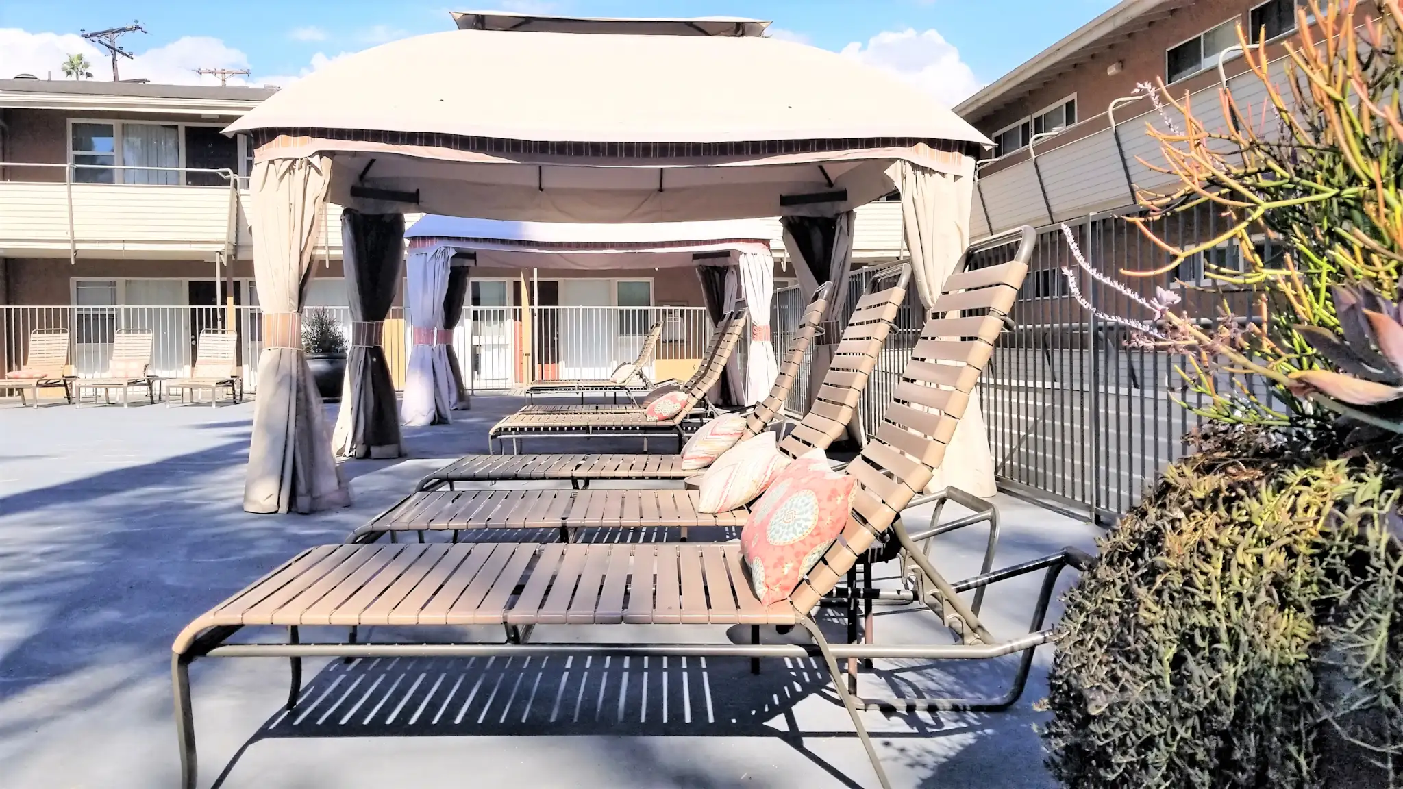 Terraces at South Pasadena pool lounge area with chairs and cabanas